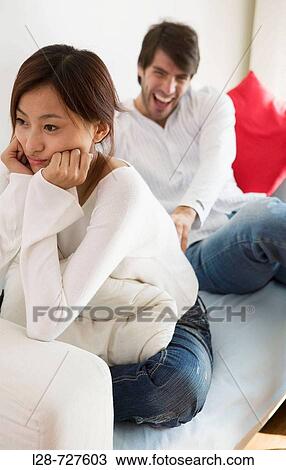 Young Couple sitting on sofa View Large Photo Image Stock Image - Young Couple sitting on sofa. Fotosearch