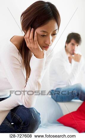 Stock Photo - Young Couple sitting on sofa. Fotosearch