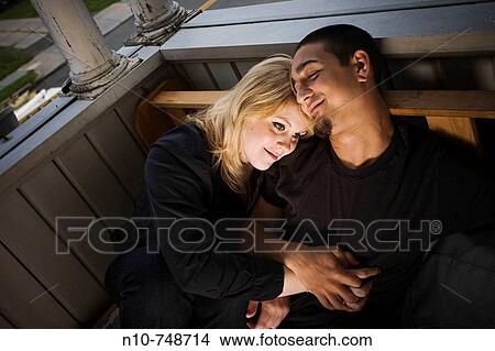 Young couple sitting on their porch. View Large Photo Image Picture - Young couple sitting on their porch.. Fotosearch