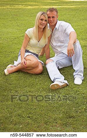 Young couple sitting together in a park. View Large Photo Image Stock Photo - Young couple sitting together in a park.. Fotosearch