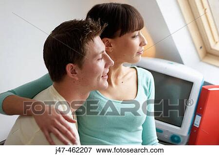 Young couple sitting together in the office looking out of window. View Large Photo Image Stock Photo - Young couple sitting together in the office looking out of window.. Fotosearch
