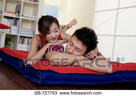 Stock Image - Young couple sleeping on bed, close-up. Fotosearch