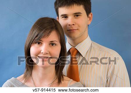 Young couple smiling and looking at the camera View Large Photo Image Stock Photography - Young couple smiling and looking at the camera. Fotosearch