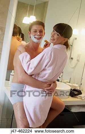 young couple standing together in underwear in the bathroom, shes helping him shave, both smiling to camera View Large Photo Image Picture - young couple standing together in underwear in the bathroom, shes helping him shave, both smiling to camera. Fotosearch