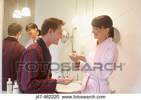 Young couple standing together in bathrobes in the bathroom laughing. View Large Photo Image Stock Image - Young couple standing together in bathrobes in the bathroom laughing.. Fotosearch