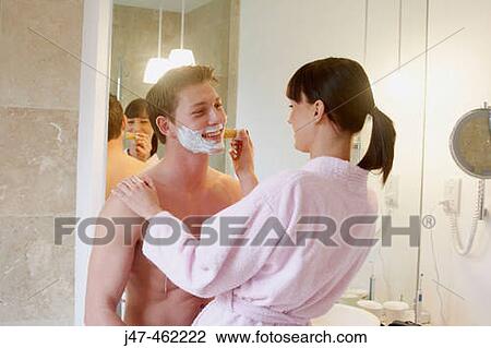 Young couple standing together in underwear in the bathroom, she is helping him shave, both smiling View Large Photo Image Stock Image - Young couple standing together in underwear in the bathroom, she is helping him shave, both smiling. Fotosearch