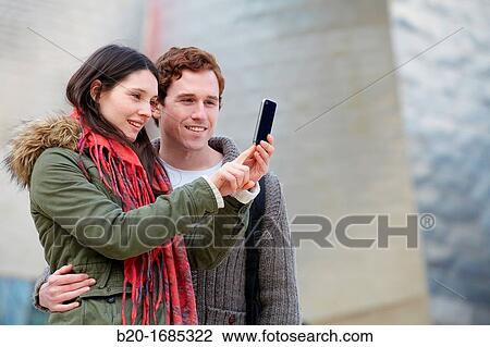 Young couple taking pictures with mobile phone in the city, smartphone, Guggenheim Museum, Abandoibarra, Bilbao, Bizkaia, Basque Country, Spain View Large Photo Image Stock Image - Young couple taking pictures with mobile phone in the city, smartphone, Guggenheim Museum, Abandoibarra, Bilbao, Bizkaia, Basque Country, Spain. Fotosearch