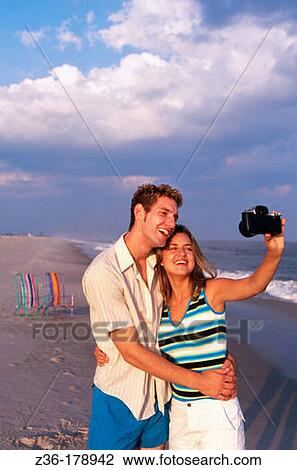 Young couple taking self-portrait with camera View Large Photo Image Stock Image - Young couple taking self-portrait with camera. Fotosearch