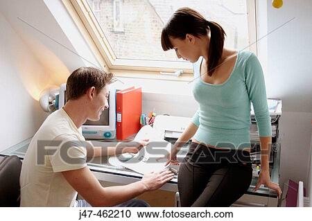 Young couple together in the office looking at a file, smiling. View Large Photo Image Stock Image - Young couple together in the office looking at a file, smiling.. Fotosearch