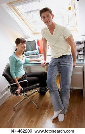 Young couple together in the office looking at the camera, smiling. View Large Photo Image Stock Photo - Young couple together in the office looking at the camera, smiling.. Fotosearch