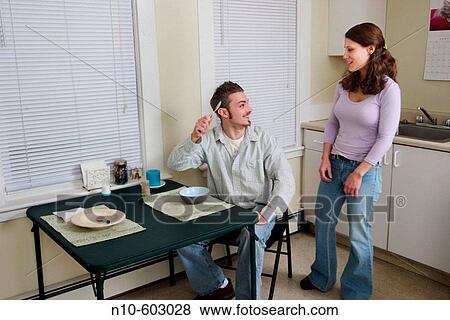 Young couple together in their kitchen. View Large Photo Image Stock Photo - Young couple together in their kitchen.. Fotosearch