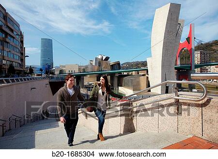Young couple visiting the city, Guggenheim Museum, Iberdrola tower, Abandoibarra, Bilbao, Bizkaia, Basque Country, Spain View Large Photo Image Picture - Young couple visiting the city, Guggenheim Museum, Iberdrola tower, Abandoibarra, Bilbao, Bizkaia, Basque Country, Spain. Fotosearch