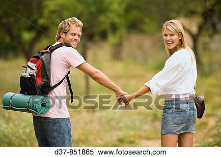 Stock Photography - Young couple walking hand in hand in the country. Fotosearch