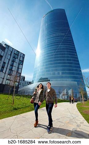 Young couple walking, Iberdrola Tower, designed by Cesar Pelli, Abandoibarra, Bilbao, Bizkaia, Basque Country, Spain View Large Photo Image Picture - Young couple walking, Iberdrola Tower, designed by Cesar Pelli, Abandoibarra, Bilbao, Bizkaia, Basque Country, Spain. Fotosearch