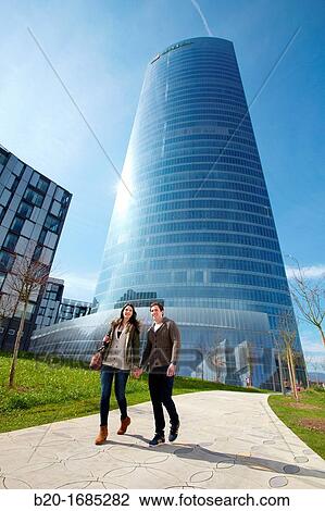 Young couple walking, Iberdrola Tower, designed by Cesar Pelli, Abandoibarra, Bilbao, Bizkaia, Basque Country, Spain View Large Photo Image Stock Image - Young couple walking, Iberdrola Tower, designed by Cesar Pelli, Abandoibarra, Bilbao, Bizkaia, Basque Country, Spain. Fotosearch