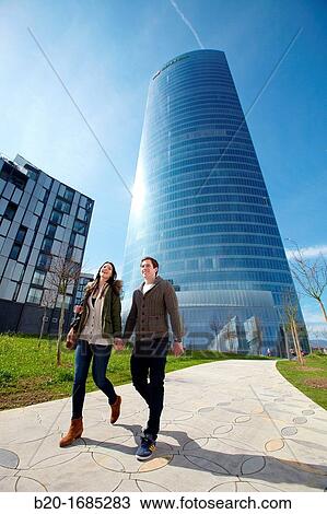 Young couple walking, Iberdrola Tower, designed by Cesar Pelli, Abandoibarra, Bilbao, Bizkaia, Basque Country, Spain View Large Photo Image Stock Image - Young couple walking, Iberdrola Tower, designed by Cesar Pelli, Abandoibarra, Bilbao, Bizkaia, Basque Country, Spain. Fotosearch