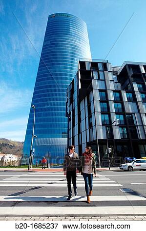 Young couple walking, Iberdrola Tower, designed by Cesar Pelli, Abandoibarra, Bilbao, Bizkaia, Basque Country, Spain View Large Photo Image Stock Photo - Young couple walking, Iberdrola Tower, designed by Cesar Pelli, Abandoibarra, Bilbao, Bizkaia, Basque Country, Spain. Fotosearch
