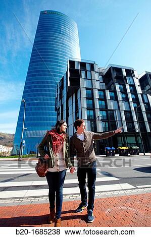Young couple walking, Iberdrola Tower, designed by Cesar Pelli, Abandoibarra, Bilbao, Bizkaia, Basque Country, Spain View Large Photo Image Stock Photo - Young couple walking, Iberdrola Tower, designed by Cesar Pelli, Abandoibarra, Bilbao, Bizkaia, Basque Country, Spain. Fotosearch