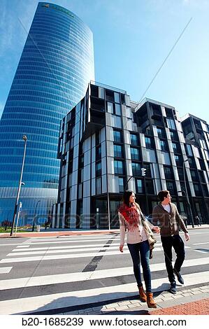 Young couple walking, Iberdrola Tower, designed by Cesar Pelli, Abandoibarra, Bilbao, Bizkaia, Basque Country, Spain View Large Photo Image Stock Photo - Young couple walking, Iberdrola Tower, designed by Cesar Pelli, Abandoibarra, Bilbao, Bizkaia, Basque Country, Spain. Fotosearch