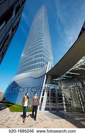 Young couple walking, Iberdrola Tower, designed by Cesar Pelli, Abandoibarra, Bilbao, Bizkaia, Basque Country, Spain View Large Photo Image Stock Photograph - Young couple walking, Iberdrola Tower, designed by Cesar Pelli, Abandoibarra, Bilbao, Bizkaia, Basque Country, Spain. Fotosearch