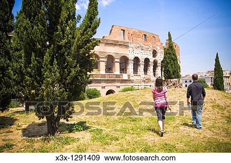 Young couple walking near Colosseum in Rome, Italy View Large Photo Image Stock Photo - Young couple walking near Colosseum in Rome, Italy. Fotosearch