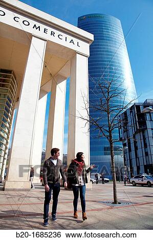 Young couple walking, Zubiarte mall, Iberdrola Tower, designed by Cesar Pelli, Abandoibarra, Bilbao, Bizkaia, Basque Country, Spain View Large Photo Image Stock Photograph - Young couple walking, Zubiarte mall, Iberdrola Tower, designed by Cesar Pelli, Abandoibarra, Bilbao, Bizkaia, Basque Country, Spain. Fotosearch