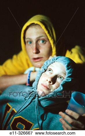 Young couple wearing hooded sweatshirts, outdoors/night View Large Photo Image Stock Photo - Young couple wearing hooded sweatshirts, outdoors/night. Fotosearch