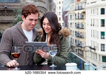 Young couple with digital tablet, digital tablet, Urban terrace bar, Alhondiga building, leisure and culture center, Bilbao, Bizkaia, Basque Country, Spain View Large Photo Image Picture - Young couple with digital tablet, digital tablet, Urban terrace bar, Alhondiga building, leisure and culture center, Bilbao, Bizkaia, Basque Country, Spain. Fotosearch