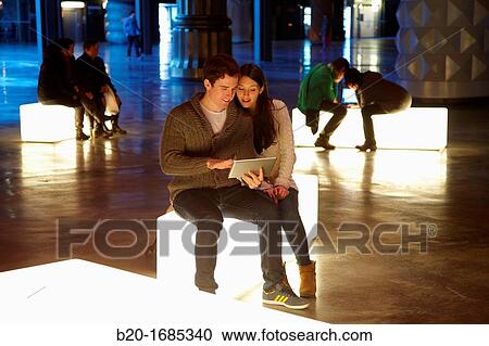 Stock Image - Young couple with digital tablet, digital tablet, Alhondiga building, leisure and culture center, Bilbao, Bizkaia, Basque Country, Spain. Fotosearch