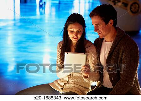 Stock Image - Young couple with digital tablet, digital tablet, Alhondiga building, leisure and culture center, Bilbao, Bizkaia, Basque Country, Spain. Fotosearch