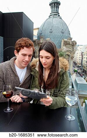 Young couple with digital tablet, digital tablet, Urban terrace bar, Alhondiga building, leisure and culture center, Bilbao, Bizkaia, Basque Country, Spain View Large Photo Image Stock Image - Young couple with digital tablet, digital tablet, Urban terrace bar, Alhondiga building, leisure and culture center, Bilbao, Bizkaia, Basque Country, Spain. Fotosearch