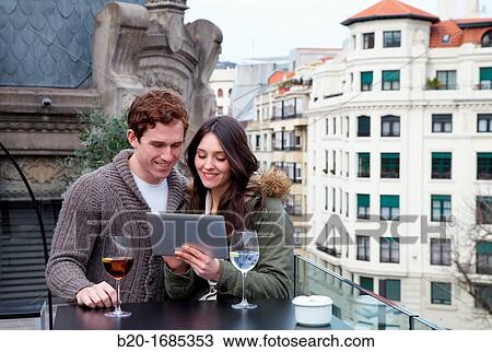 Young couple with digital tablet, digital tablet, Urban terrace bar, Alhondiga building, leisure and culture center, Bilbao, Bizkaia, Basque Country, Spain View Large Photo Image Stock Image - Young couple with digital tablet, digital tablet, Urban terrace bar, Alhondiga building, leisure and culture center, Bilbao, Bizkaia, Basque Country, Spain. Fotosearch