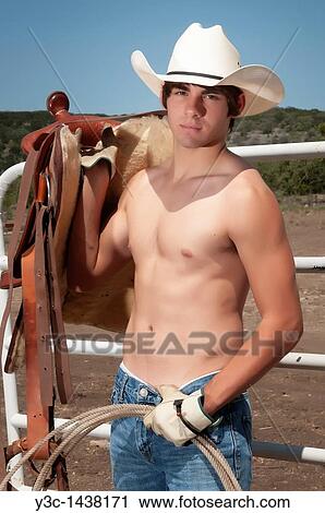 Young cowboy posing with saddle and rope View Large Photo Image Stock Image - Young cowboy posing with saddle and rope. Fotosearch