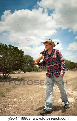 Stock Image - Young cowboy with rifle. Fotosearch