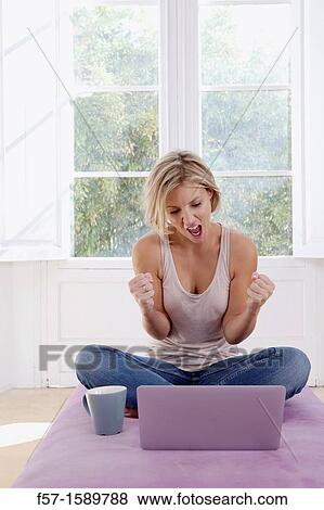 Stock Photo - Young, excited woman online. Fotosearch