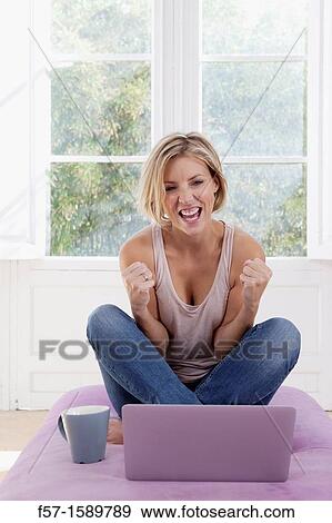 Stock Photo - Young, excited woman online. Fotosearch