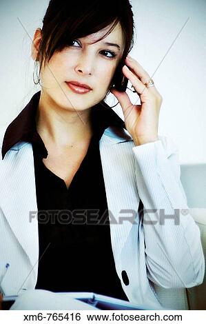 Young executive talking on a mobile phone while waiting transportation View Large Photo Image Stock Photograph - Young executive talking on a mobile phone while waiting transportation. Fotosearch