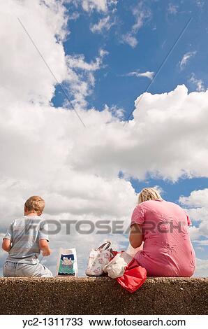 Young family eat their fish and chips on the beach at Aldeburgh, Suffolk, England, Great Britain, Uk View Large Photo Image Stock Image - Young family eat their fish and chips on the beach at Aldeburgh, Suffolk, England, Great Britain, Uk. Fotosearch