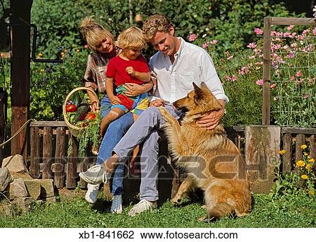 Young family with a dog in their vegetable garden View Large Photo Image Stock Image - Young family with a dog in their vegetable garden. Fotosearch
