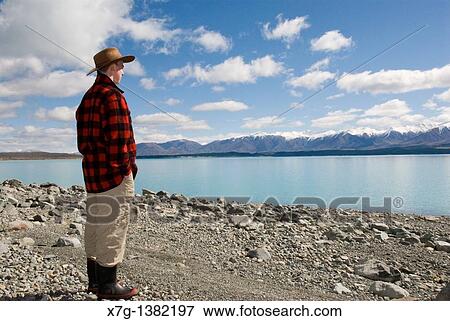 Young farmer looking out at Lake Pukaki, South Island of New Zealand View Large Photo Image Stock Photo - Young farmer looking out at Lake Pukaki, South Island of New Zealand. Fotosearch