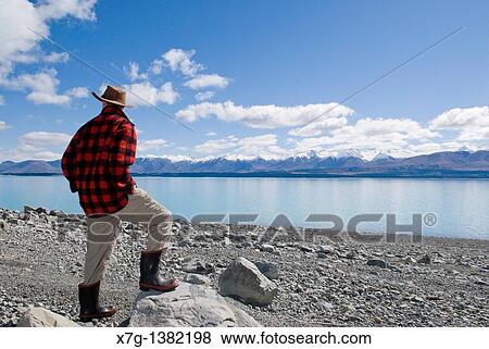 Young farmer looking out at Lake Pukaki, South Island of New Zealand View Large Photo Image Stock Photo - Young farmer looking out at Lake Pukaki, South Island of New Zealand. Fotosearch