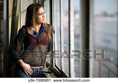 Young, fashionable woman from Afghanistan, living in asylum in the Netherlands, posing near the docks of Rotterdam harbor, leaning against the window of an old, abandoned industrial building. View Large Photo Image Stock Image - Young, fashionable woman from Afghanistan, living in asylum in the Netherlands, posing near the docks of Rotterdam harbor, leaning against the window of an old, abandoned industrial building.. Fotosearch