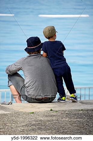 young father and his little son spending time together, waterside, summertime View Large Photo Image Stock Image - young father and his little son spending time together, waterside, summertime. Fotosearch