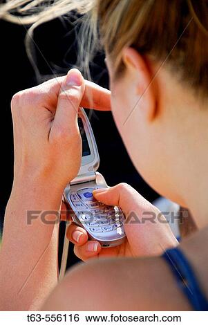 young female adult shading cellphone while dialing View Large Photo Image Stock Photograph - young female adult shading cellphone while dialing. Fotosearch
