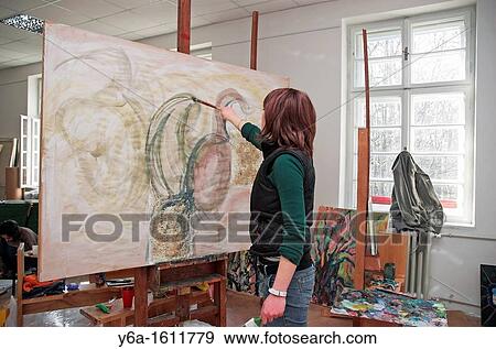 Young female art student painting View Large Photo Image Stock Photo - Young female art student painting. Fotosearch