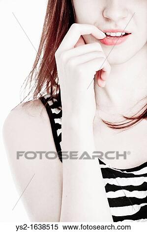 Young female biting her fingernail View Large Photo Image Stock Photography - Young female biting her fingernail. Fotosearch