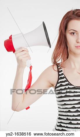 Stock Photograph - Young female holding a megaphone by her ear. Fotosearch
