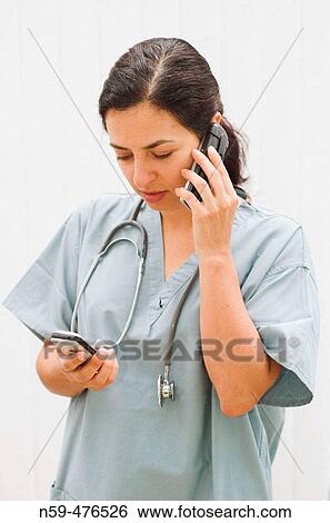 Stock Photograph - Young female medical professional juggling busy life.. Fotosearch