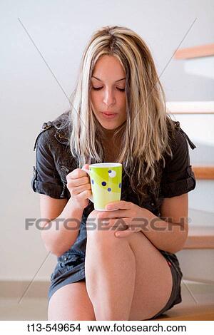 Young female with a cup of hot drink in her hands View Large Photo Image Picture - Young female with a cup of hot drink in her hands. Fotosearch