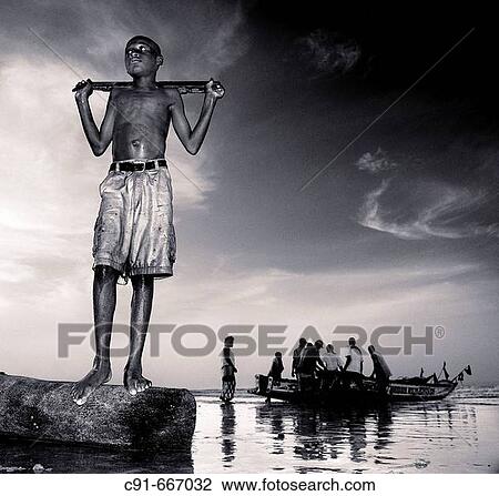 Stock Image - Young fisherman in the evening. Gambia. Fotosearch